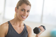 Mulher feliz que levanta peso no health club foto de stock Mulher feliz que levanta peso no health club foto de stock