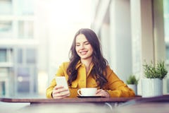 Mulher feliz que texting no smartphone no café da cidade fotografia de stock Mulher feliz que texting no smartphone no café da cidade fotografia de stock