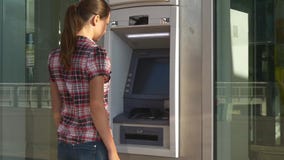 A mulher introduz o cartão de operação bancária no ATM video estoque A mulher introduz o cartão de operação bancária no ATM video estoque