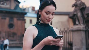 Mulher lindo que usa ativamente seu dispositivo no centro da cidade, olhando ao redor, texting para trás Olhar à moda, beleza nat filme Mulher lindo que usa ativamente seu dispositivo no centro da cidade, olhando ao redor, texting para trás Olhar à moda, beleza nat filme