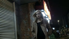 Mulher loura bonita no ar livre sozinho de passeio do revestimento na noite grão Movimento lento filme Mulher loura bonita no ar livre sozinho de passeio do revestimento na noite grão Movimento lento filme