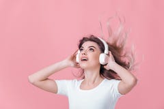 A mulher loura bonita nos fones de ouvido brancos escuta a música imagens de stock A mulher loura bonita nos fones de ouvido brancos escuta a música imagens de stock