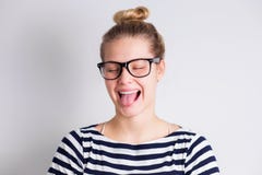 Mulher loura nova engraçada louca nos vidros que mostram a língua e que sorriem no fundo branco fotos de stock Mulher loura nova engraçada louca nos vidros que mostram a língua e que sorriem no fundo branco fotos de stock
