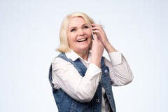Mulher loura superior de sorriso que fala no telefone foto de stock Mulher loura superior de sorriso que fala no telefone foto de stock