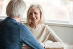 Mulher madura de sorriso que escuta o homem que fala, datar velho dos pares imagens de stock royalty free Mulher madura de sorriso que escuta o homem que fala, datar velho dos pares imagens de stock royalty free