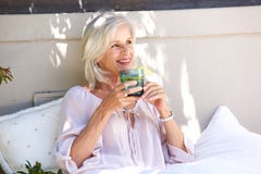 Mulher mais idosa relaxado fora do chá bebendo com limão imagem de stock Mulher mais idosa relaxado fora do chá bebendo com limão imagem de stock