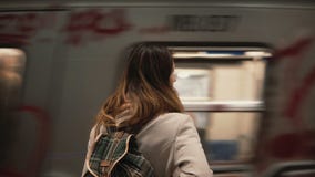 Mulher moreno que está na estação de trem e que espera seu trem A menina dentro no subsolo na noite olha em bondes rápidos video estoque Mulher moreno que está na estação de trem e que espera seu trem A menina dentro no subsolo na noite olha em bondes rápidos video estoque
