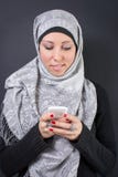 Mulher muçulmana no hijab que guarda um telefone celular Imagens de Stock Mulher muçulmana no hijab que guarda um telefone celular Imagens de Stock