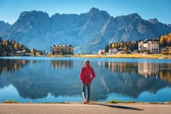 Mulher na costa do lago Misurina no nascer do sol no outono imagens de stock royalty free Mulher na costa do lago Misurina no nascer do sol no outono imagens de stock royalty free