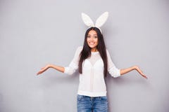 Mulher nas orelhas de coelho que shrugging seus ombros imagem de stock Mulher nas orelhas de coelho que shrugging seus ombros imagem de stock