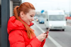 Mulher no perfil que guarda um telefone, texting uma parte externa dos sms em um bu fotos de stock Mulher no perfil que guarda um telefone, texting uma parte externa dos sms em um bu fotos de stock