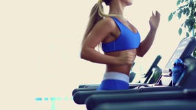 Mulher nova da aptidão que faz cardio- exercícios no gym que corre em uma escada rolante vídeos de arquivo Mulher nova da aptidão que faz cardio- exercícios no gym que corre em uma escada rolante vídeos de arquivo
