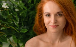 Mulher nova do ruivo que toca em sua cara, fundo verde foto de stock Mulher nova do ruivo que toca em sua cara, fundo verde foto de stock
