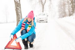 A mulher põr inverno de advertência da avaria do carro do triângulo foto de stock royalty free A mulher põr inverno de advertência da avaria do carro do triângulo foto de stock royalty free