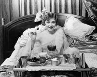 Mulher que come o café da manhã na cama (todas as pessoas descritas não são umas vivas mais longo e nenhuma propriedade existe Ga imagens de stock royalty free Mulher que come o café da manhã na cama (todas as pessoas descritas não são umas vivas mais longo e nenhuma propriedade existe Ga imagens de stock royalty free