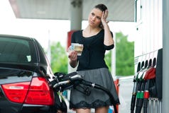 Mulher que conta o dinheiro no posto de gasolina foto de stock royalty free Mulher que conta o dinheiro no posto de gasolina foto de stock royalty free
