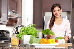 Mulher que cozinha na cozinha nova