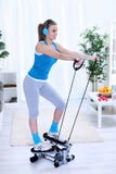 Mulher que exercita em casa no instrutor deslizante fotografia de stock royalty free Mulher que exercita em casa no instrutor deslizante fotografia de stock royalty free