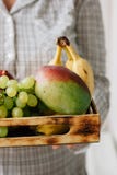 Mulher que guarda a caixa com frutos nas mãos Fotos de Stock Mulher que guarda a caixa com frutos nas mãos Fotos de Stock