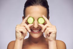 Mulher que guarda fatias de pepino sobre os olhos imagens de stock royalty free Mulher que guarda fatias de pepino sobre os olhos imagens de stock royalty free