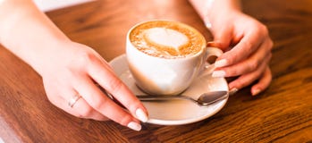 Mulher que guardara a chávena de café quente, com forma do coração Imagens de Stock Mulher que guardara a chávena de café quente, com forma do coração Imagens de Stock