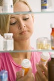 Mulher que olha no gabinete de medicina foto de stock Mulher que olha no gabinete de medicina foto de stock