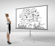 Mulher que olha o flipchart fotos de stock royalty free Mulher que olha o flipchart fotos de stock royalty free