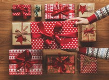 Mulher que organiza presentes de Natal belamente envolvidos do vintage no fundo de madeira, imagem com embaçamento imagem de stock royalty free Mulher que organiza presentes de Natal belamente envolvidos do vintage no fundo de madeira, imagem com embaçamento imagem de stock royalty free