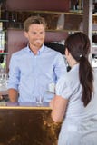 Mulher que senta-se na barra que fala com barman foto de stock Mulher que senta-se na barra que fala com barman foto de stock