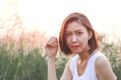 Mulher que senta-se no campo de grama imagem de stock Mulher que senta-se no campo de grama imagem de stock