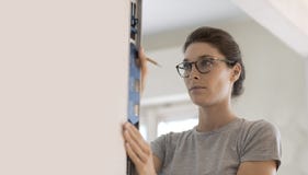 Mulher que trabalha com um nível de espírito imagem de stock Mulher que trabalha com um nível de espírito imagem de stock