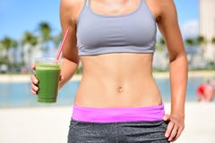 Mulher saudável do estilo de vida que bebe o batido verde