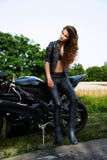 Mulher sexual do motociclista com sua motocicleta fotografia de stock royalty free Mulher sexual do motociclista com sua motocicleta fotografia de stock royalty free