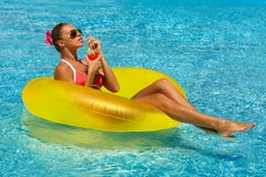Mulher 'sexy' no biquini que aprecia o sol do verão e que bronzea-se durante feriados na associação com um cocktail foto de stock Mulher 'sexy' no biquini que aprecia o sol do verão e que bronzea-se durante feriados na associação com um cocktail foto de stock