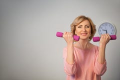 Mulher superior feliz que faz o treinamento da aptidão com pesos fotografia de stock Mulher superior feliz que faz o treinamento da aptidão com pesos fotografia de stock