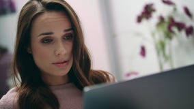 Mulher Tired que trabalha no portátil Mulher forçada com a dor de cabeça que olha o portátil filme Mulher Tired que trabalha no portátil Mulher forçada com a dor de cabeça que olha o portátil filme