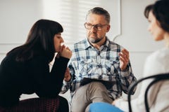 Mulher árabe que escuta seu psychotherapist durante o grupo de apoio o encontro dos sobreviventes do abuso fotografia de stock royalty free Mulher árabe que escuta seu psychotherapist durante o grupo de apoio o encontro dos sobreviventes do abuso fotografia de stock royalty free