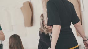 Mulheres do alfaiate que tomam medidas da camisa usando o medidor da fita video estoque Mulheres do alfaiate que tomam medidas da camisa usando o medidor da fita video estoque