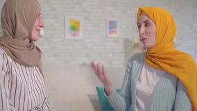Mulheres muçulmanas novas surdas bonitas do retrato dois nos hijabs que falam com linguagem gestual no fim da sala de visitas aci vídeos de arquivo Mulheres muçulmanas novas surdas bonitas do retrato dois nos hijabs que falam com linguagem gestual no fim da sala de visitas aci vídeos de arquivo