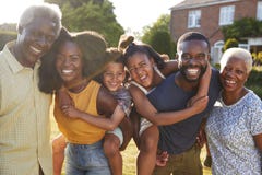 Multi generation black family, parents piggybacking kids