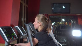 Multi povos étnicos que mantêm o ajuste exercitar no equipamento moderno do gym Ostenta mulheres bonitas no gym O jogo do instrut video estoque Multi povos étnicos que mantêm o ajuste exercitar no equipamento moderno do gym Ostenta mulheres bonitas no gym O jogo do instrut video estoque