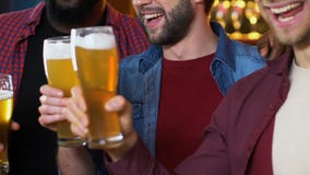 Multiethnic male friends clinking beer glasses, evening in pub, leisure time stock video footage Multiethnic male friends clinking beer glasses, evening in pub, leisure time stock video footage