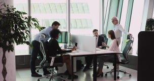 Multiethnic staff using computers talking in big office
