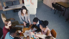 Multiethnic δημιουργικό 'brainstorming' ομάδων τοπ άποψης στο καθιερώνον τη μόδα σύγχρονο coworking γραφείο Ο θηλυκός προϊστάμενο απόθεμα βίντεο Multiethnic δημιουργικό 'brainstorming' ομάδων τοπ άποψης στο καθιερώνον τη μόδα σύγχρονο coworking γραφείο Ο θηλυκός προϊστάμενο απόθεμα βίντεο