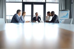 Multiethnische Geschäftsleute, die Diskussion am Konferenztische im Büro haben lizenzfreie stockbilder Multiethnische Geschäftsleute, die Diskussion am Konferenztische im Büro haben lizenzfreie stockbilder