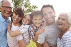 Multigeneratiefamilie die Kinderenvervoer per kangoeroewagen in openlucht geven stock foto Multigeneratiefamilie die Kinderenvervoer per kangoeroewagen in openlucht geven stock foto