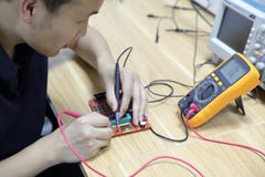 Multimetersondes die een raad van de computerkring onderzoeken stock afbeelding Multimetersondes die een raad van de computerkring onderzoeken stock afbeelding
