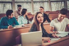 Multinational group of cheerful students taking an active part in a lesson while sitting in a lecture Hall. royalty free stock image Multinational group of cheerful students taking an active part in a lesson while sitting in a lecture Hall. royalty free stock image