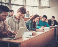 Multinational group of cheerful students taking an active part in a lesson while sitting in a lecture Hall. stock photo Multinational group of cheerful students taking an active part in a lesson while sitting in a lecture Hall. stock photo