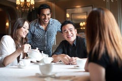 Multiracial friends in restaurant smiling royalty free stock images Multiracial friends in restaurant smiling royalty free stock images